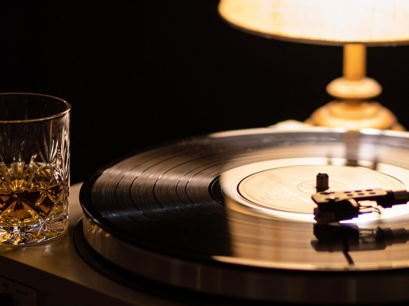 A record on the turntable beside a glass of amber spirit